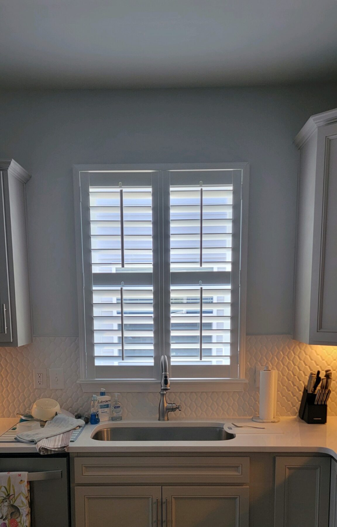 Energy-efficient plantation shutters installed in a kitchen window, enhancing indoor comfort and aesthetic appeal while reducing energy bills.