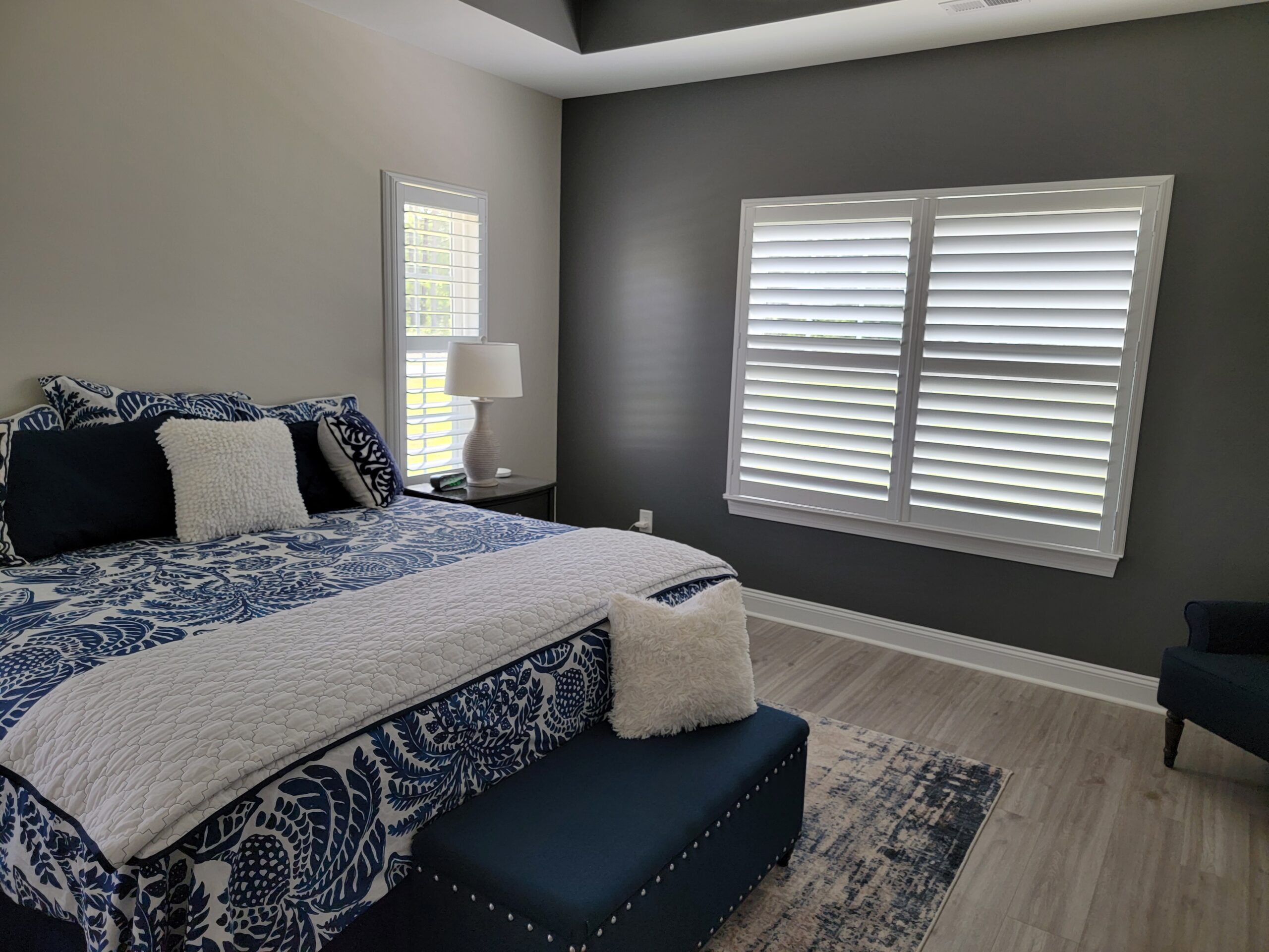Energy-efficient plantation shutters in a modern bedroom, enhancing comfort and aesthetics, with a cozy bed and stylish decor.