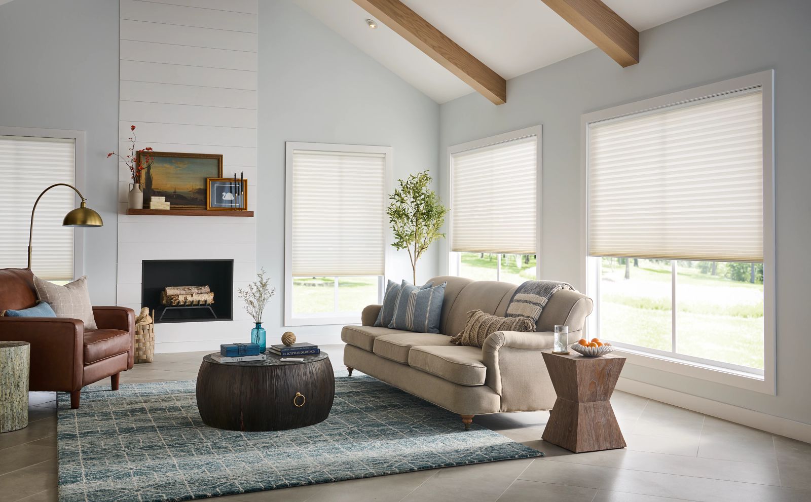 Cozy living room featuring energy-efficient poly shutters on windows, a beige sofa with decorative pillows, a wooden coffee table, and a stylish side table, promoting home comfort and eco-friendly design.