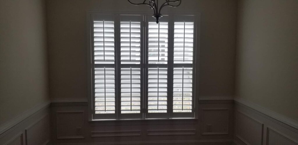 Window featuring white plantation shutters, enhancing natural light and aesthetics in a residential space, showcasing interior design elements relevant to window treatments.