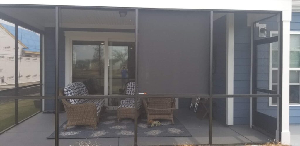 Screened porch featuring wicker furniture and outdoor rug, showcasing a stylish window treatment option for enhancing outdoor living spaces.