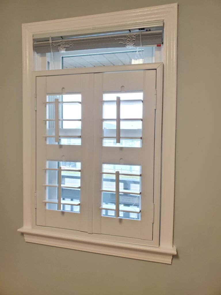 White plantation shutters installed in a window, enhancing interior aesthetics and natural light control, relevant to window treatment options offered by Plantation Shutter Pros.