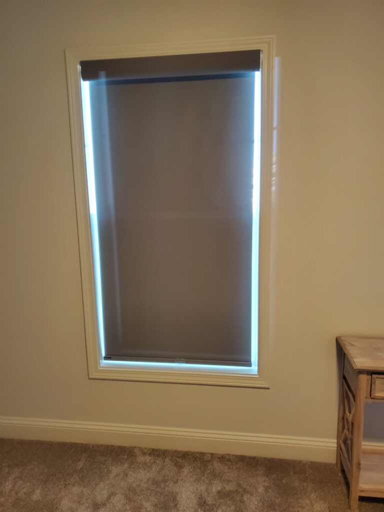 Brown window shade partially covering a window in a residential setting, showcasing a modern window treatment option for home aesthetics.