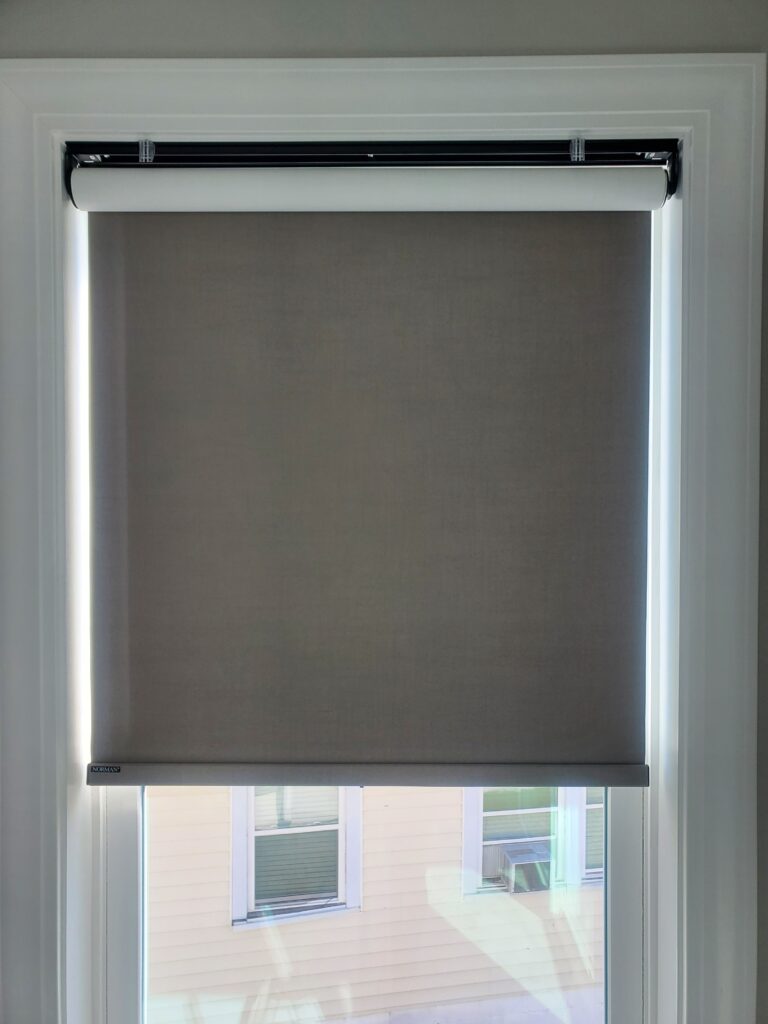 Roller window shade in a residential setting, showcasing a neutral fabric color, enhancing the aesthetic appeal of home interiors.